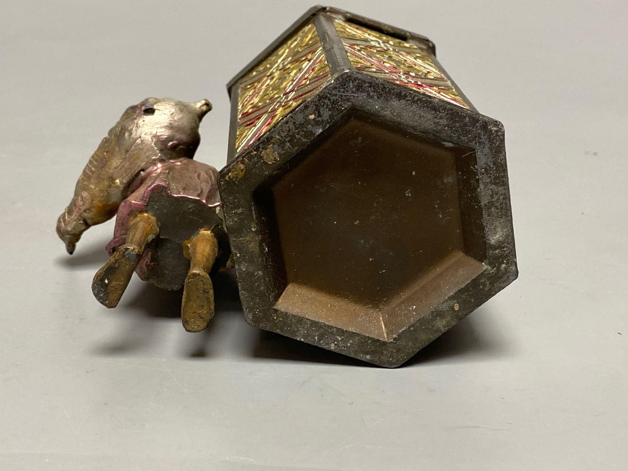 A Bergman style cold painted metal hexagonal casket, with hinged cover, Itinerant labourer alongside, 15cm